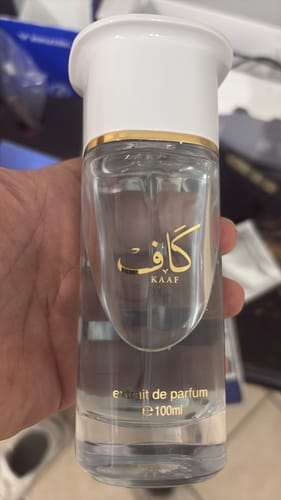 Un cliente sostiene en la mano el frasco de perfume transparente de 100 ml.