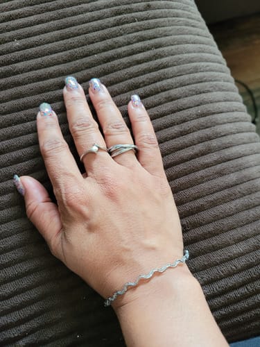 Customer showing the silver-colored Tidal Roller Ring on their hand, styled with other jewelry.