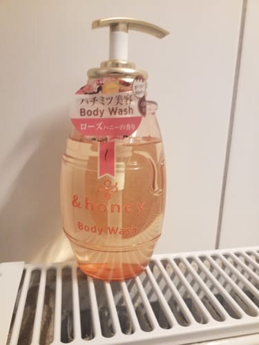 Customer's bottle of & Honey Melty Moist Rose Body Wash sitting on a white radiator.