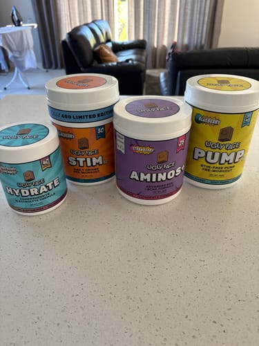 Reviewer's UGLYFACE® AMINOS+ supplement tub among other UGLYFACE products on a counter.