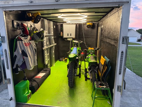 Customer's green 5 Gallon Jug in a trailer with a matching green floor and two motocross bikes.