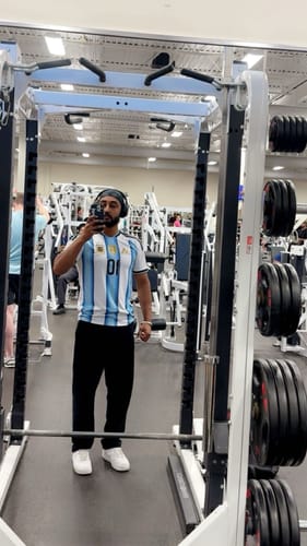Reviewer at the gym wearing a black Lah Bandana as a headband under headphones.