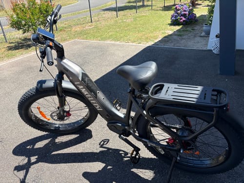 Customer's Lankeleisi MG600 Plus fat bike parked on a paved driveway, showing its grey frame and rear rack.