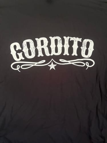 Close-up of the customer's black Gordito T-shirt, highlighting the white distressed 'Gordito' text with a star flourish.