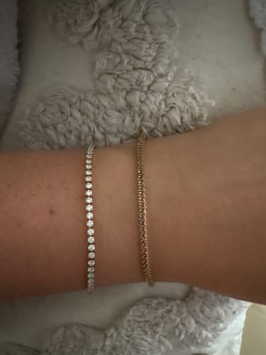 Customer's wrist wearing the silver-colored Elise Bracelet next to another gold-colored bracelet.