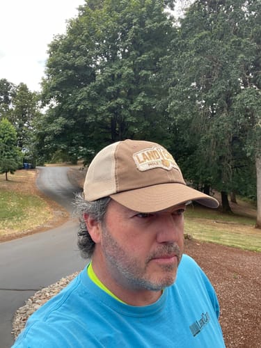 Customer wearing the faded brown Big Unstructured Trucker Hat outdoors.