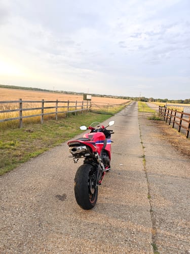 Reviewer's red motorcycle showing the installed universal Plate Light on the tail.