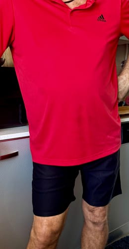 Reviewer wearing the black Ultra-Stretch 7" Chino Shorts with a red polo shirt, showing the fit.