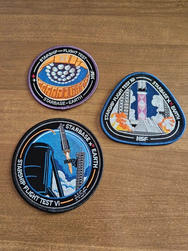 Customer's collection of three embroidered Starship mission patches arranged on a wooden surface.