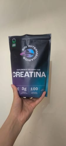 Cliente sosteniendo el empaque negro del suplemento Creatina Monohidrato.