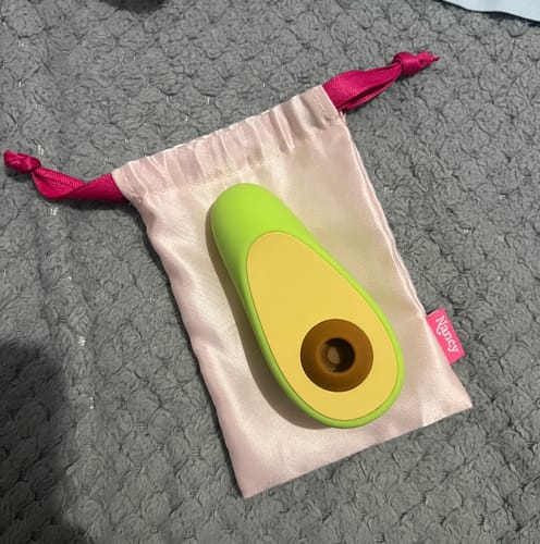 Customer's green Avo Clitoral Massager on its pink satin storage bag.