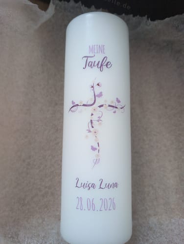 Ein Kunde zeigt seine personalisierte weiße Taufkerze 'Blumenkreuz' mit Namen und Datum.