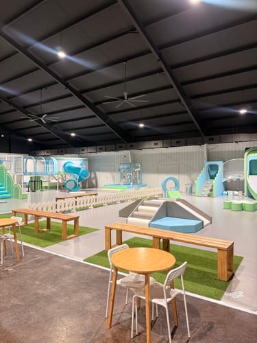 Customer's white plastic fences enclosing a section of an indoor play area.