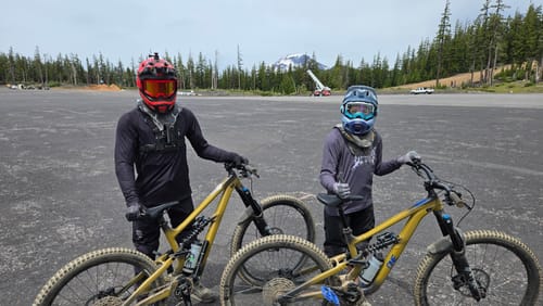 A customer wearing the black Reaper Long Sleeve Flowteq™ Jersey with a neck brace and mountain bike at a park.