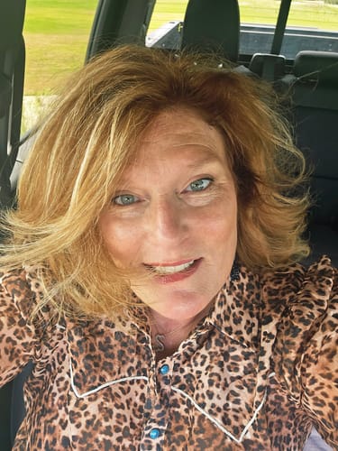 Reviewer's close-up selfie wearing the leopard print Western Wild top, highlighting the turquoise snap buttons.