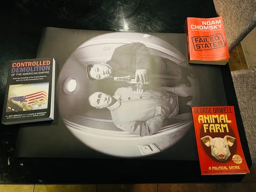 Customer's 'The Good Stuff' art print laid out on a table next to three political books.
