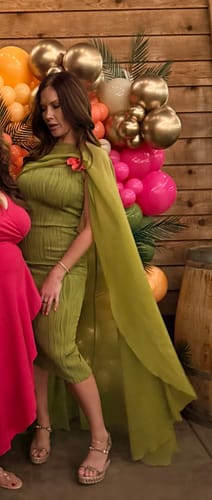 Close-up of the reviewer wearing the green Chiffon Cape Crop Top, showing the drape of the cape and textured dress.