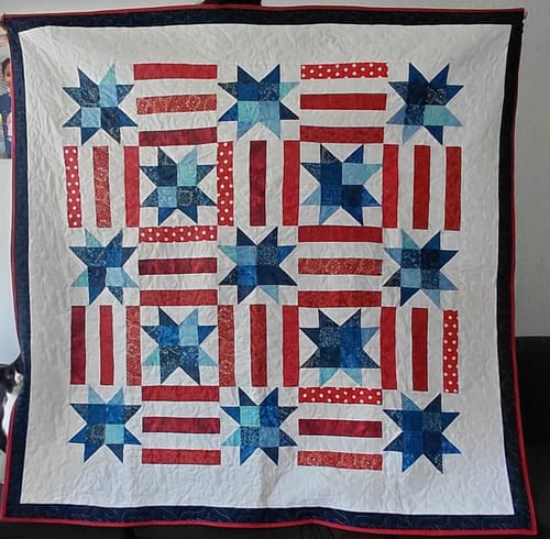 Reviewer's finished quilt made from the Red, White, and Cute kit, featuring a patriotic star and stripe pattern.