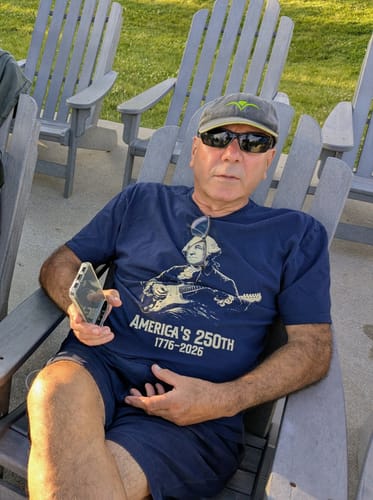 Customer sitting outdoors in a chair wearing the navy Washington 250 T-Shirt.