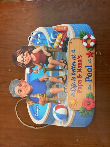 Customer's personalized wood sign showing 'Papa & Nana' as cartoon figures relaxing by a pool.
