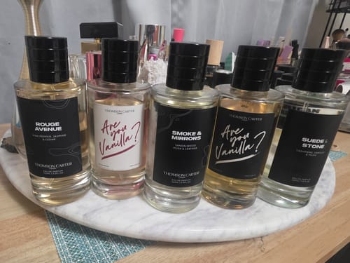 Reviewer's Smoke & Mirrors Eau de Parfum bottle shown with other fragrances from the same brand.