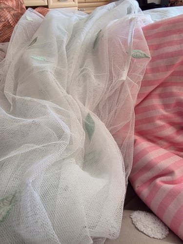 Customer's 30-metre fabric bundle, featuring a white sheer fabric with green embroidered leaves and a pink striped fabric.