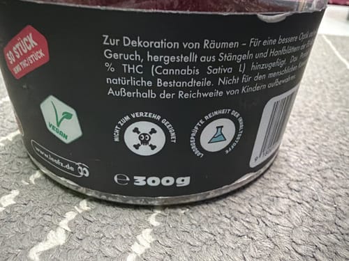 Kundenbild: Nahaufnahme des Etiketts auf der Dose der THC Space Cubes mit Warnhinweisen und Vegan-Symbol.