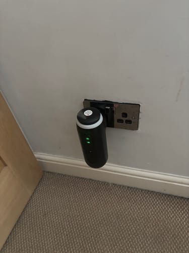 Customer's black plug-in diffuser for Celestial Hideaway fragrance oil, seen plugged into a wall outlet.