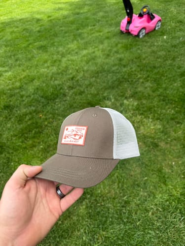 Customer holding the brown Big Trucker Hat, showing its white mesh back.