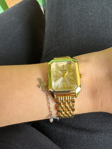 A reviewer wearing the gold, vintage-style CLAIRE DE MAINS watch on their wrist.
