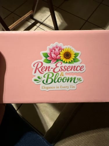 Customer's custom vinyl sticker with a floral logo applied to a pink box.