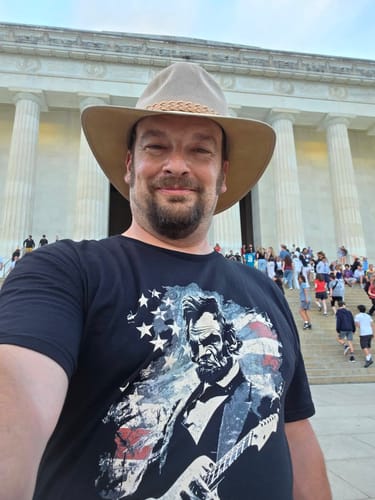 Reviewer in a Lincoln Flag T-Shirt taking a selfie in front of the Lincoln Memorial.