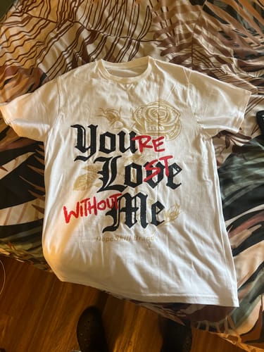 Customer's white TAN Collection DopeSkill T-Shirt with 'You’re Lost Without Me' graphic laid flat on a bed.