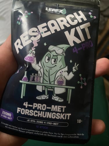 Ein Kunde hält die schwarze Verpackung des 4-Pro-MET Forschungskits in der Hand.
