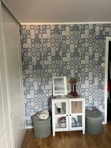 En kunde viser en fondvegg dekket med dekorativ Cassablue tiles kontaktplast i et rom.