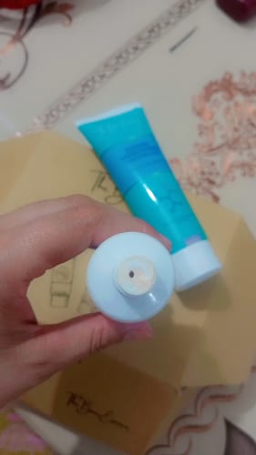 Close-up of a reviewer's hand holding a product from the Eco Pigmentation Bundle, showing the nozzle.