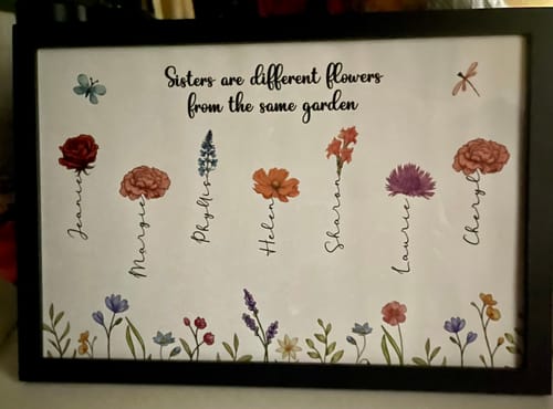 Customer's framed 'Sisters' poster, personalized with seven flowers and names to represent each sibling.