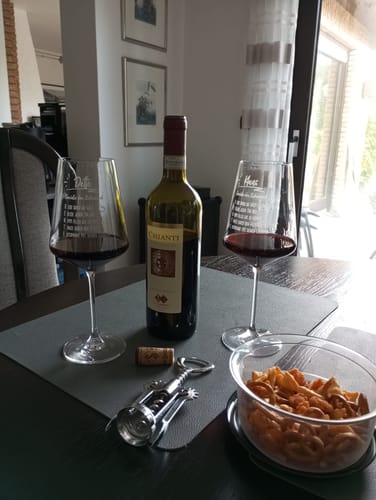 Kundenfoto von zwei gravierten Leonardo Weingläsern, gefüllt mit Rotwein auf einem Tisch mit Snacks.