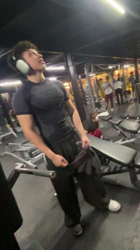 Reviewer in a gym wearing the dark, fitted Superman Compression Tee.