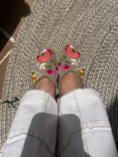 Cliente mostrando las alpargatas Daniela Beige en sus pies, con el bordado de flores visible.