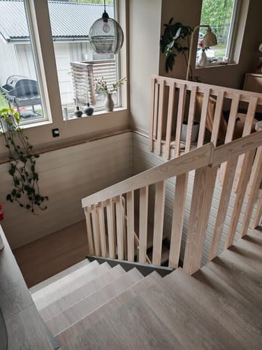 Kundens renoverte trapp med Santana Eik Kalk kontaktplast på trinnene, sett ovenfra i et lyst rom.