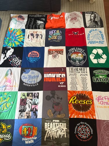 Customer's Project Repat T-Shirt Quilt laid out, showcasing a large, colorful grid of shirts from concerts, sports, and school.