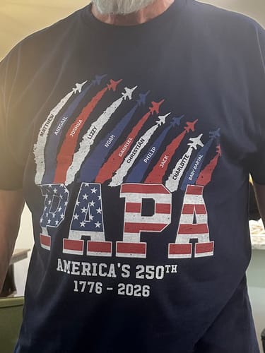 Customer wearing the personalized 'PAPA' patriotic shirt, showing the custom names of his grandchildren on the front.