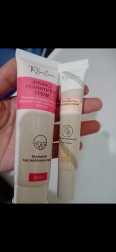 Customer's hand holding a large tube of Advance Face Pigmentation Cream next to a smaller lip cream tube.
