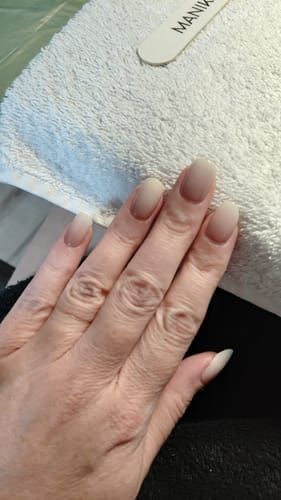 Hand einer Kundin mit den 'Babyboomer Nude' UV-Gel-Nagelfolien auf mittellangen, ovalen Nägeln.