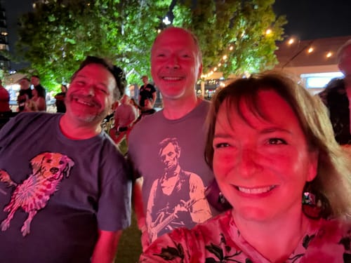 Customer wearing the grey Lincoln Guitar T-Shirt in a group at an outdoor night event.