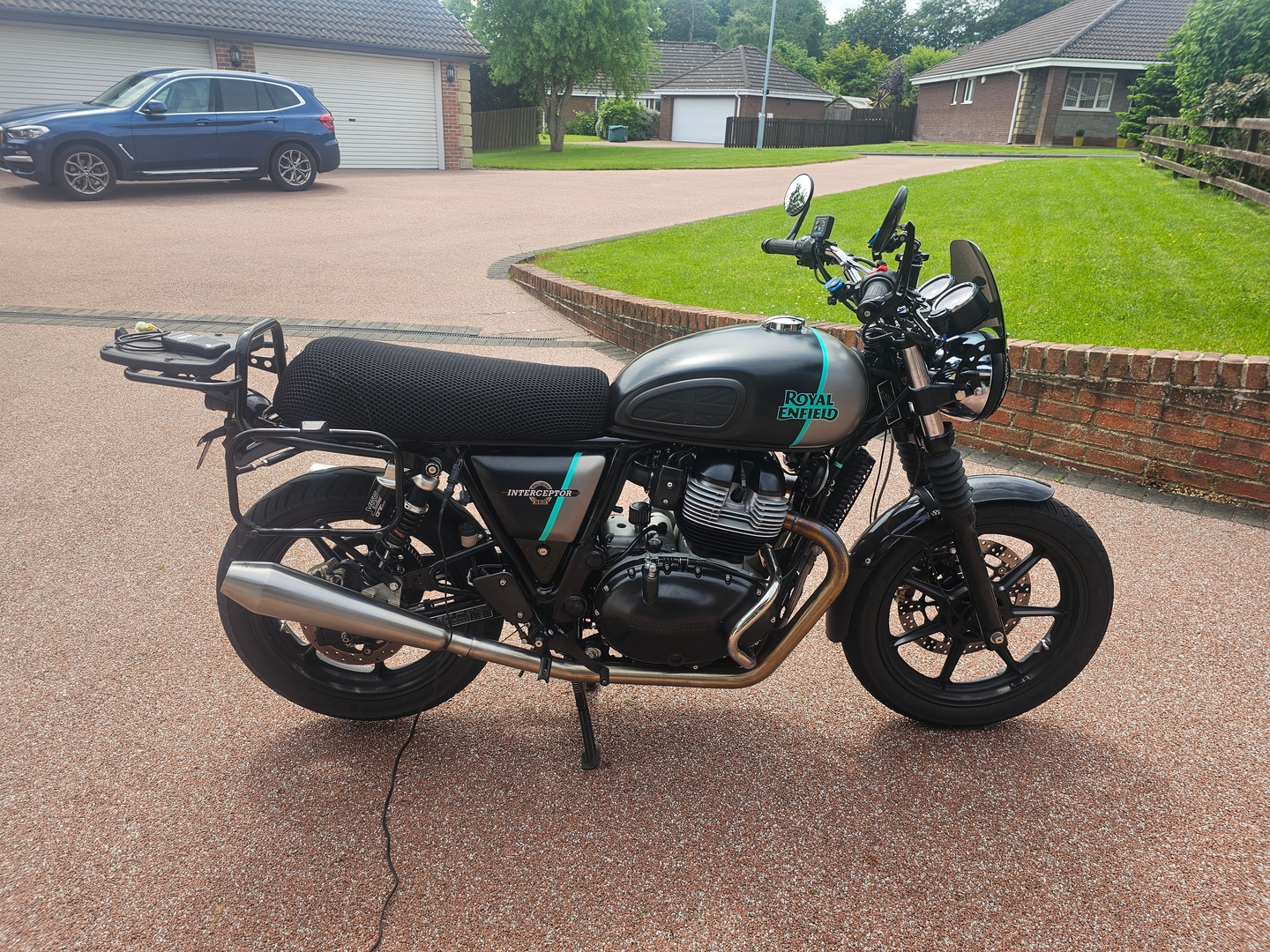 Wind Rider 3D mesh seat cover installed on a Royal Enfield Interceptor, full bike visible in a driveway