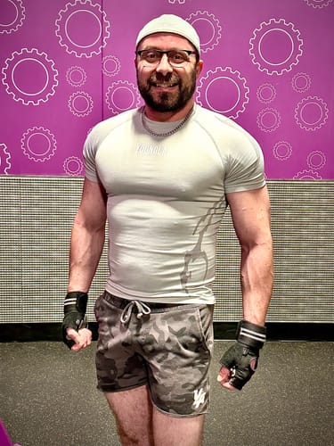 Reviewer at the gym, showing the tight fit of the light gray Gothic Compression Tee.