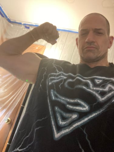 Reviewer flexing in the black Superman Cut-Offs shirt, showing the front graphic.