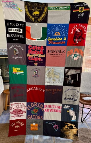 A reviewer's finished Project Repat T-Shirt Quilt, a large and colorful patchwork made from many different shirts.